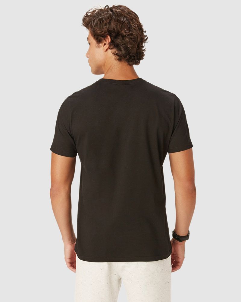 Homem branco e cabelo castanho utilizando camiseta básica preta masculina com decote redondo e esponto em algodão.