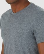 Homem negro de cabelo preto utilizando camiseta básica cinza masculina gola V em algodão e calça jeans.
